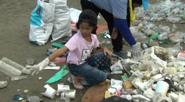 Schoolchildren help to clean rubbish from polluted beach in southern Thailand