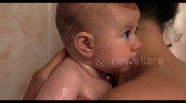 tender moment of cute baby girl enjoying bath time with her mother