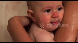 tender moment of cute baby girl enjoying bath time with her mother