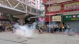 Hong Kong riot police fire tear gas at protesters from footbridge on Hennessy Road