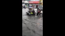 Motorists drive through flooded road after heavy rain in the Philippines