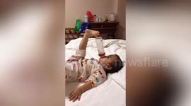 Hands-free! Ingenious baby uses TOE to hold milk bottle in place while feeding herself