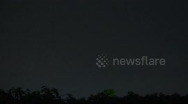 An airplane flies into a lightning storm, over Pathumthani, Thailand. (closeup version).