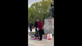 German painting a swastika on the Soviet War Memorial Treptow, Berlin