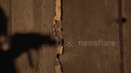 The shadow of the machine gunner on the wall in motion