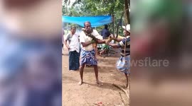 Spine-tingling moment 10ft python coils itself around builder's neck and leaves him choking for breath in rural Indian village