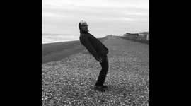 Man leaning into gale force winds on beach