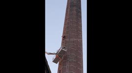 Emergency crews retrieve man stranded on top of chimney in England