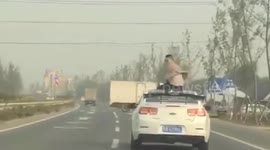 Chinese man sits on car roof as vehicle's radio 'was too loud'