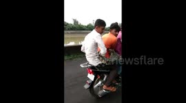 Brave men rescue crocodile and carry it with them on bike in western India