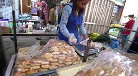 Hundreds of bees swarm a woman's pastry stand at a market in Uzbekistan