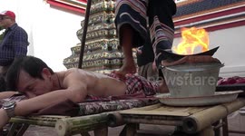 Tourists grit their teeth through sizzling hot fire massages in Thailand