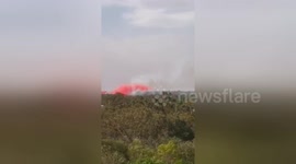 Plane drops fire-retardant on bushfires in Sydney outskirts