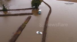 Dramatic drone footage shows UK delivery van driver stranded as flood-hit road turns into a river