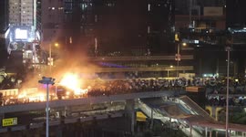 Moment Hong Kong protesters set riot police vehicle alight outside Polytechnic University