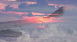 A dream holiday to Thailand, flying over a sunrise ocean.