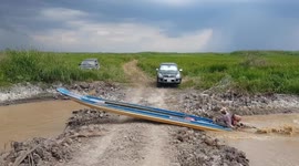 Canal boat takes shortcut over road in Cambodia