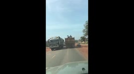 Children sit on top of dumpster truck to ride to school in Cambodia