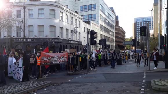 thousands of young people protesting in Bristol at climate change, walking through city, holding up buses, carrying banners and chanting act now