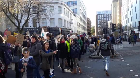 thousands line Bristol City Centre to protest against climate change, carrying banners and signs