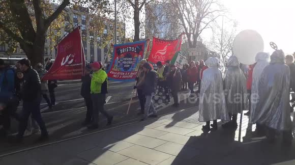 protesters in costume line the streets of Bristol rallying against climate change and Black Friday consumerism