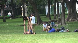 Keep-fit enthusiasts practice lifting each other up in the park