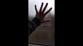 Woman smashes ice from car window after freezing rain in Hanover, Canada