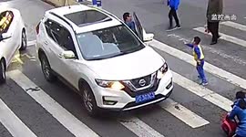 Furious child kicks out at car that knocked over his mother at zebra crossing in China