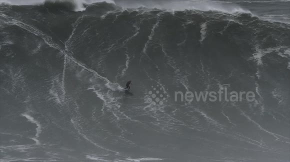 Surfers take to the sea off Nazare to tackle huge 65ft waves