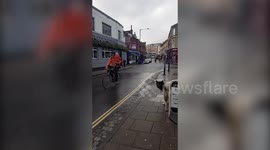 This cyclist has been slammed after he was filmed riding with one hand on the handlebar and the other holding a young CHILD - with neither wearing a helmet