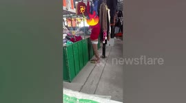 Bizarre moment woman tries on underwear over leggings at Thai market