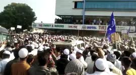 Protesters in India crowd round police vehicle and rock it back and forth