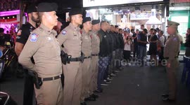 Police and gogo dancers in Santa costumes hand out gifts in Thailand