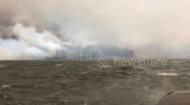 Surrounded by the fires 17people stranded in a boat fleeing for their lives after their homes, caravans and cars burnt