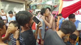 Youngsters lick peanut butter from each other's FACES in bizarre village game in the Philippines