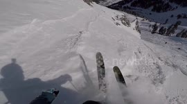 Skier laughs as he lands 360 off side of cliff barely missing rocks