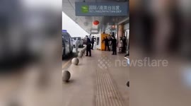 Suspected coronavirus patient wheeled out of Chinese airport in see-through quarantine box
