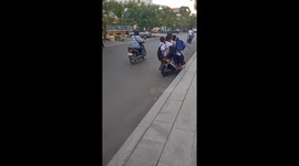 Five schoolboys cram onto one moped after lessons finish in Cambodia
