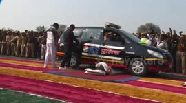 Indian police officer lets vehicles drive over his stomach