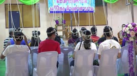 Faithful Buddhist followers, attend a ceremony with ropes attached to their heads, where they pray and offer flowers, and get blessed by Monks.