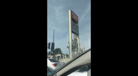 Man standing on forklift to change a sign