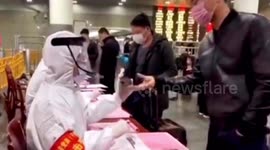 Train station staff in China wear protective clothing to check commuters amid coronavirus outbreak