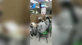 Chinese workers separated by cardboard as they eat to avoid spread of coronavirus