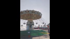 Painful moment woman riding fairground swing is flung into metal railings