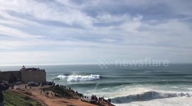 Spectators cheer as prosurfer rides monster wave during big wave season at Nazaré, Portugal