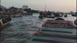 Boat stocked with yellow flowers on river in Vietnam