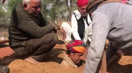 Indian farmers bury themselves chest-deep in the ground to protest land reforms