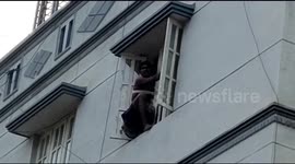 Botched burglar gets stuck on third floor ledge in India and has to be saved by firemen