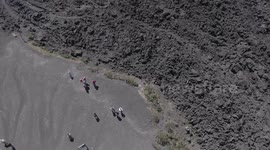 Tourists walk on old magma of Pacaya