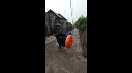 Locals turn alley with rapid floodwater into makeshift water park in Bali